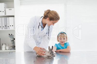 Vet showing a young girl a bunny rabbit