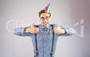 Geeky hipster wearing party hat smiling at camera