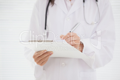 Doctor writing on clipboard