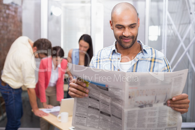 Smiling man reading the newspaper