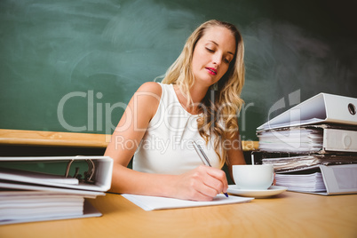 Beautiful businesswoman writing document at desk