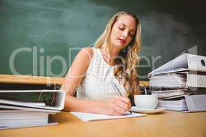 Beautiful businesswoman writing document at desk