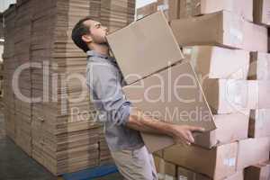 Worker carrying boxes in warehouse