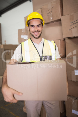 Worker carrying box in warehouse