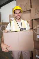 Worker carrying box in warehouse