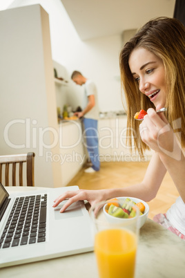 Woman eating fruit salad at breakfast