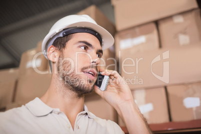 Worker using cellphone in warehouse