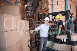 Warehouse manager talking with forklift driver