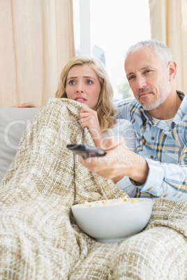 Happy couple watching a movie on the couch