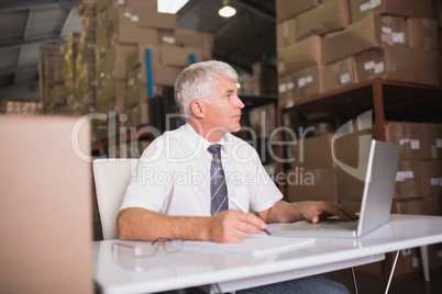 Warehouse manager using laptop