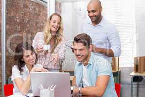 Business team laughing together in front of the laptop