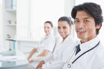 Smiling doctors sitting beside each other