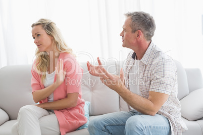 Unhappy couple arguing on the couch