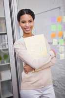 Smiling creative businesswoman holding folder