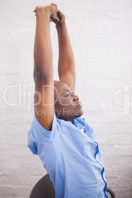 Businessman sitting with arms raised at desk Businessman sitting with arms raised at desk