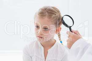 Doctor examining patient with magnifying glass