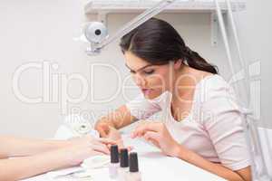 Nail technician giving customer a manicure