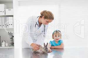 Vet showing a young girl a bunny rabbit