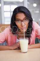 Woman drinking a glass of milk while looking the camera