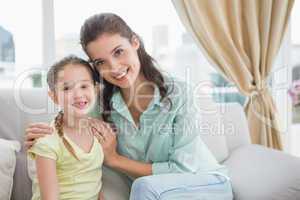 Cute mother and daughter smiling at camera