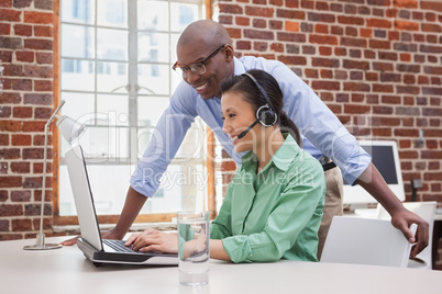 Casual business team working together with laptop