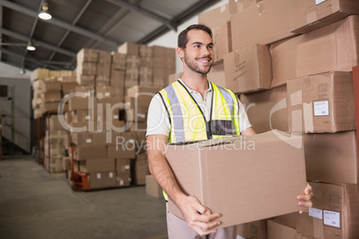 Worker carrying box in warehouse