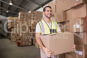 Worker carrying box in warehouse