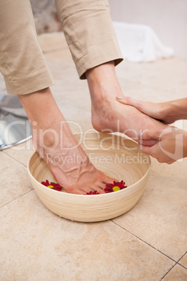 Pedicurist cleansing customer feet