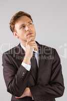 Young businessman thinking with hand on chin