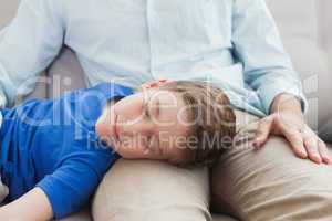 Father and son using napping on the couch