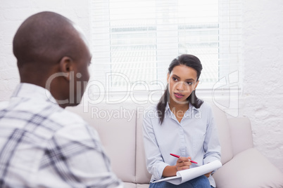 Man sitting with therapist taking notes