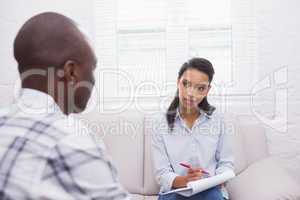Man sitting with therapist taking notes