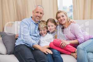 Happy parents with their children on sofa