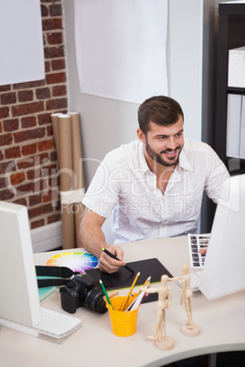 Smiling designer working on his computer