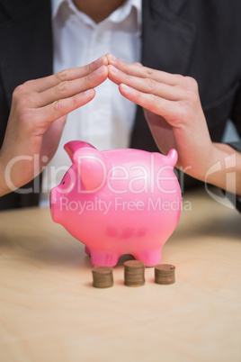 Close up of hands over piggy bank