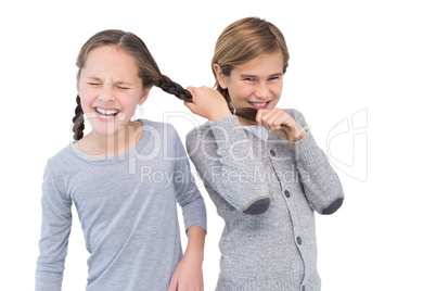 Angry young boy pulling sister hair in a fight