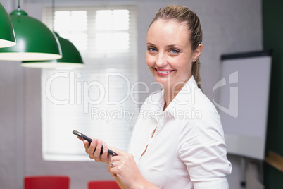 Blonde smiling businesswoman using smartphone