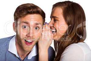 woman whispering secret into friends ear