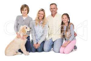 Family with their dog posing and smiling at camera together