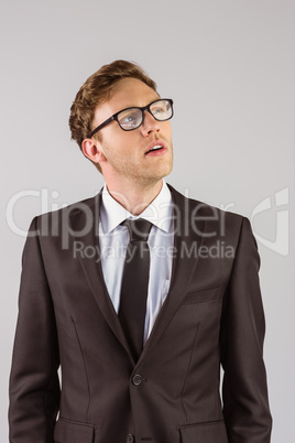 Young businessman thinking and looking up