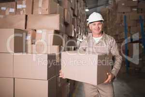 Worker carrying box in warehouse