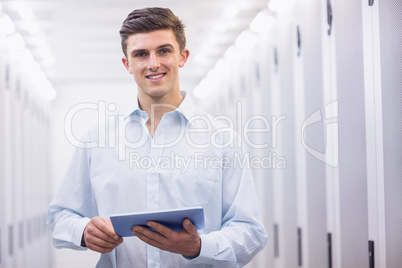 Smiling young technician working with his tablet