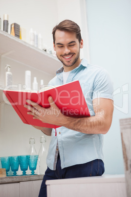 Smiling hairdresser with stock book