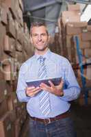 Manager using digital tablet in warehouse