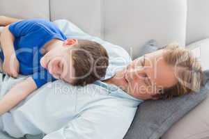 Father and son using napping on the couch