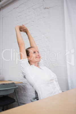 Businesswoman stretching hands in office