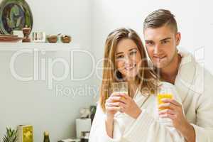 Couple drinking orange juice in bathrobes