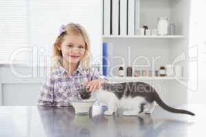 Happy owner petting her cat drinking milk