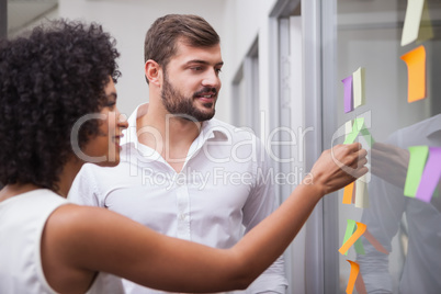 Casual business team looking at sticky notes