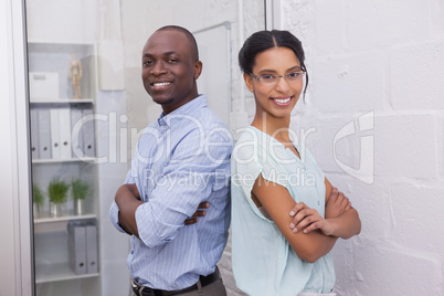 Smiling business people with arms folded